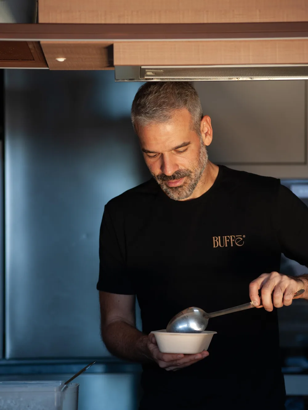 Gabriel Buffé servindo uma refeição na cozinha